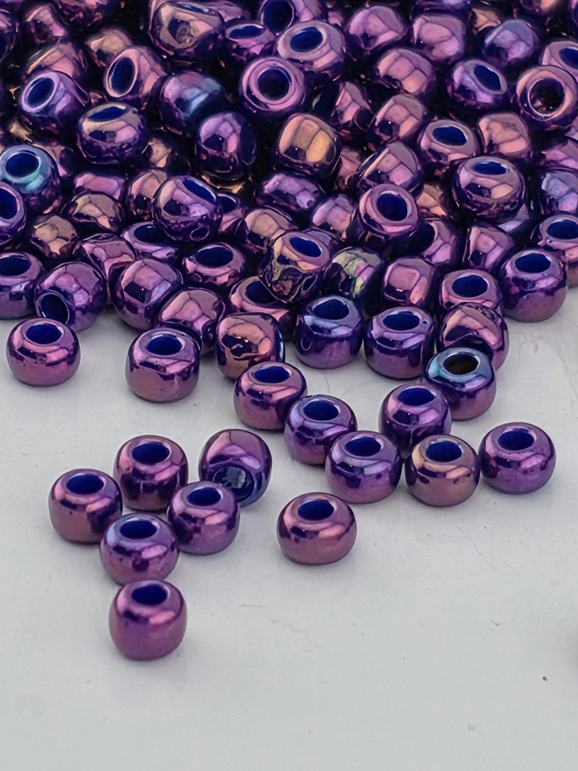 a collection of purple and blue beads scattered on a white surface.