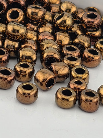 a close-up view of numerous small, shiny, metallic beads in various shapes and sizes, scattered across a surface.