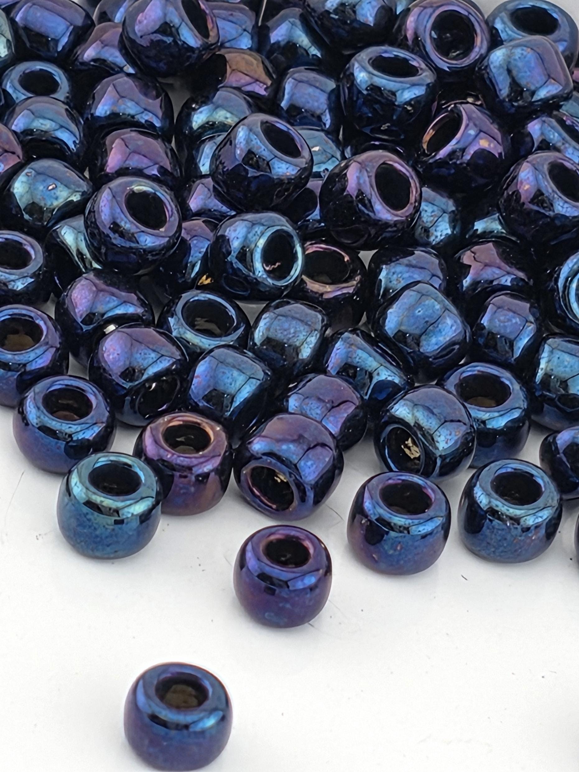 a collection of blue and purple beads scattered on a white surface.