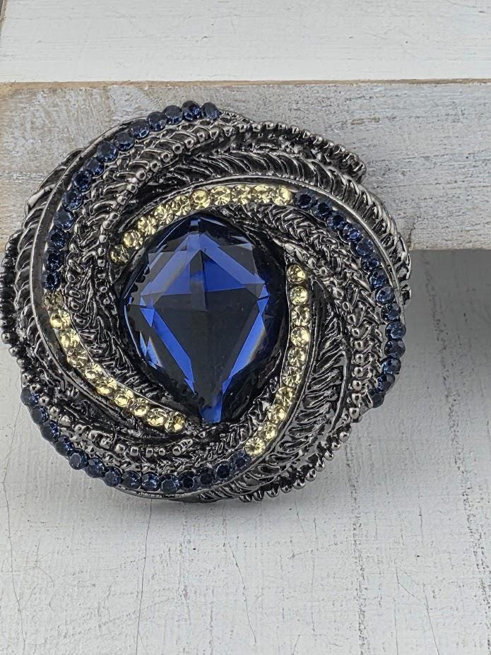 a large, blue gemstone set in a decorative metal frame.