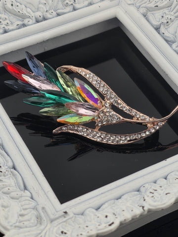 A decorative piece of jewelry with a colorful, multicolored design and sparkling rhinestones or crystals.