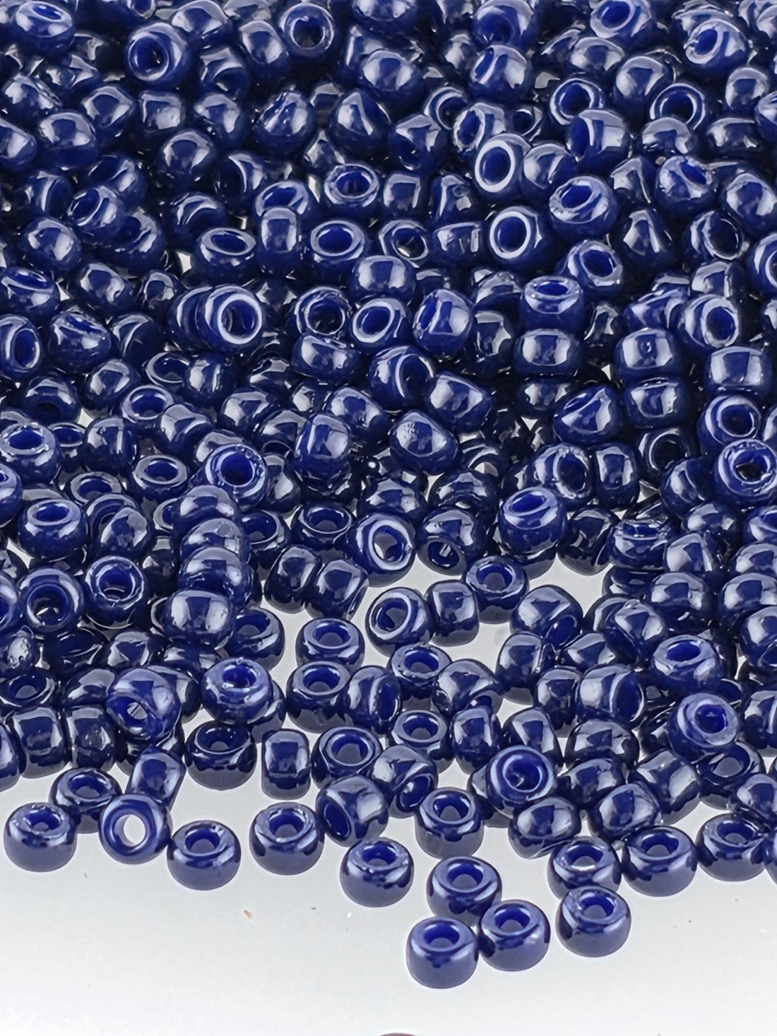 a large pile of small, round, blue beads scattered across a surface.
