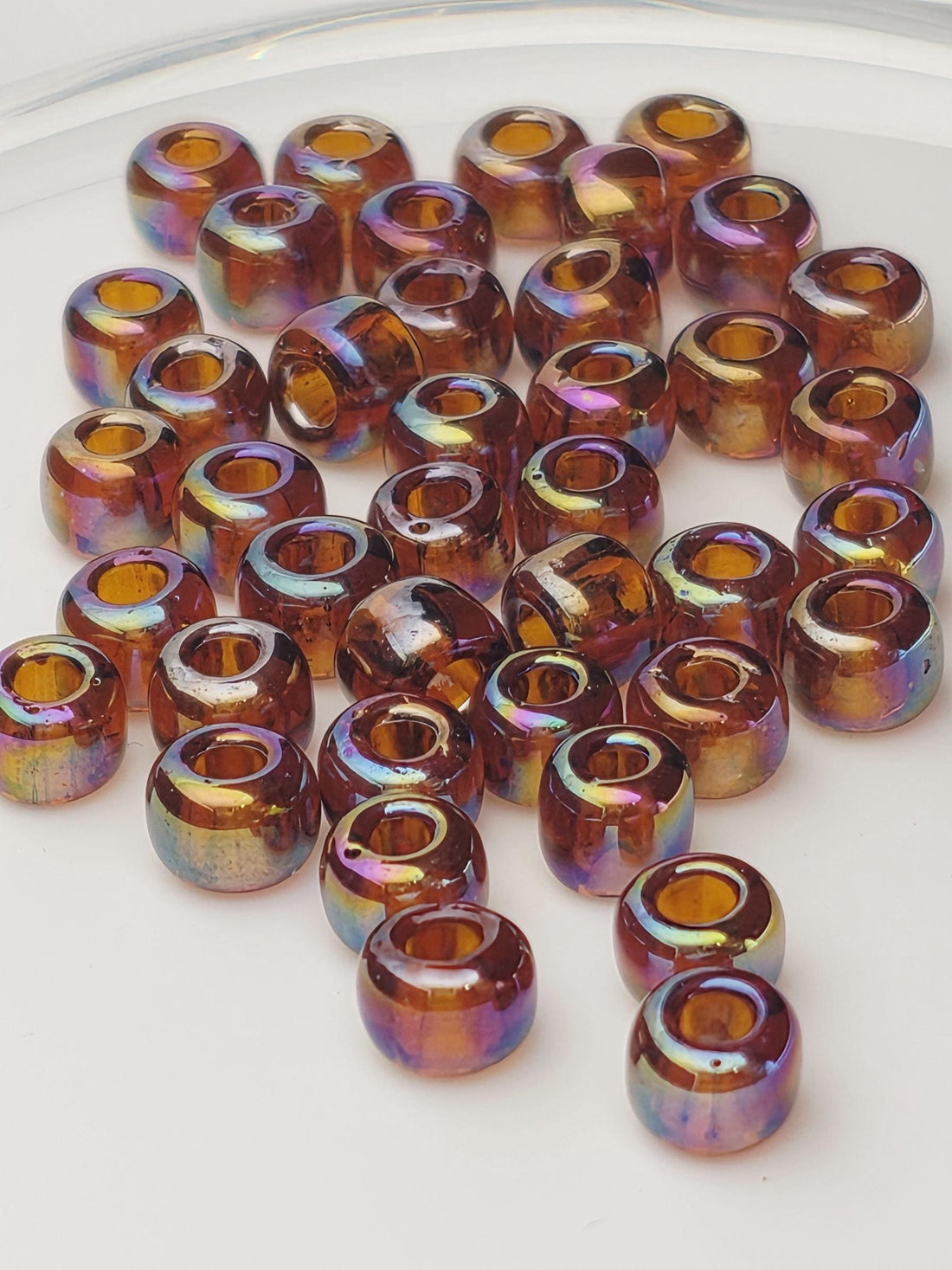 a collection of multicolored glass beads scattered on a white surface.