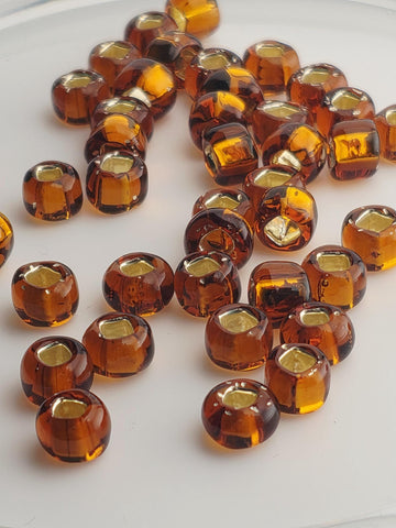 a collection of brown glass beads scattered on a white surface.