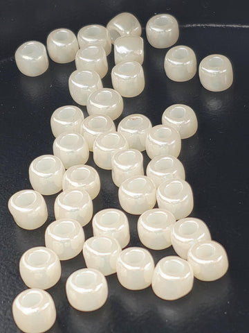 a collection of white, round beads scattered on a dark surface.