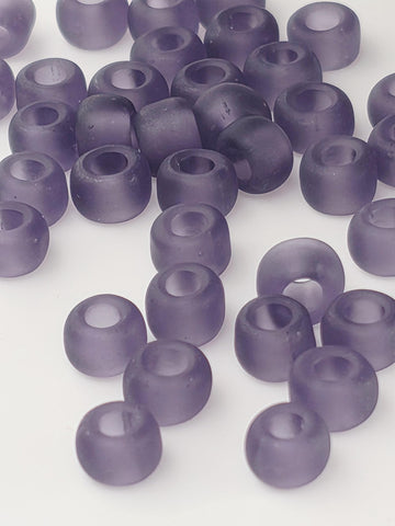 numerous purple glass beads scattered across a white background.
