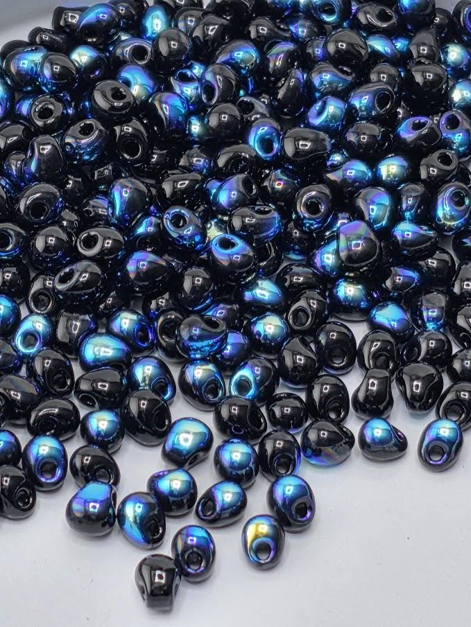 a large pile of black and blue beads scattered across a surface.