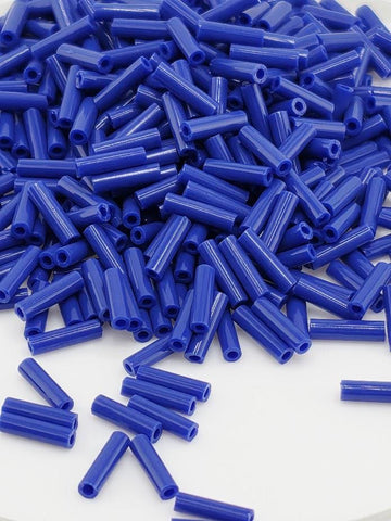 a large pile of blue plastic tubes or rods scattered on a white surface.