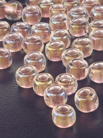 a close-up view of numerous clear glass beads arranged in a pattern on a dark surface.