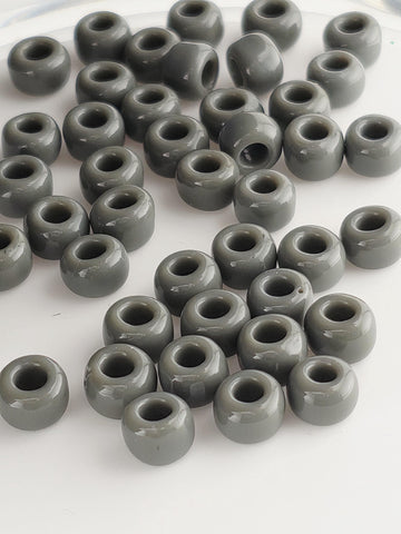 a collection of grey beads or objects arranged in a pattern, possibly on a white surface.