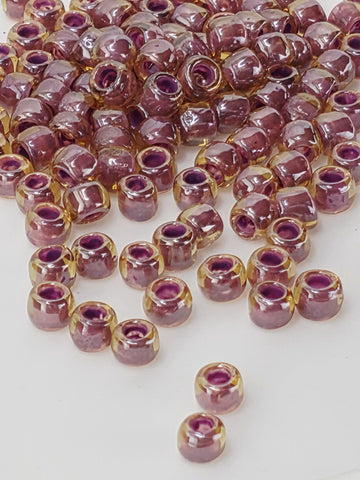 a collection of small, round beads in shades of purple and yellow, scattered on a white surface.