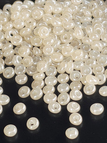 a close-up view of numerous small, clear beads scattered across a dark background.