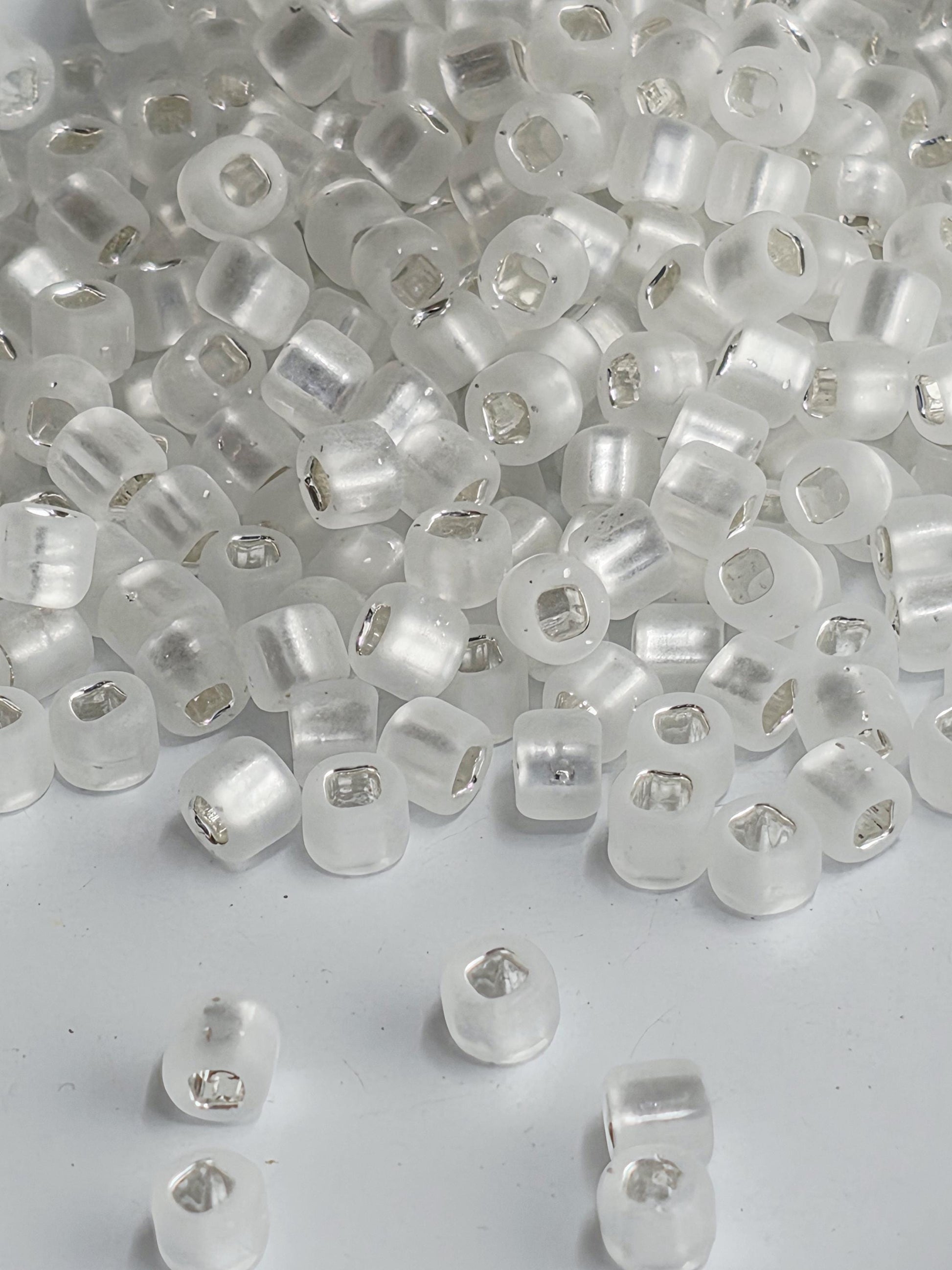 a large pile of clear, transparent beads scattered on a white surface.
