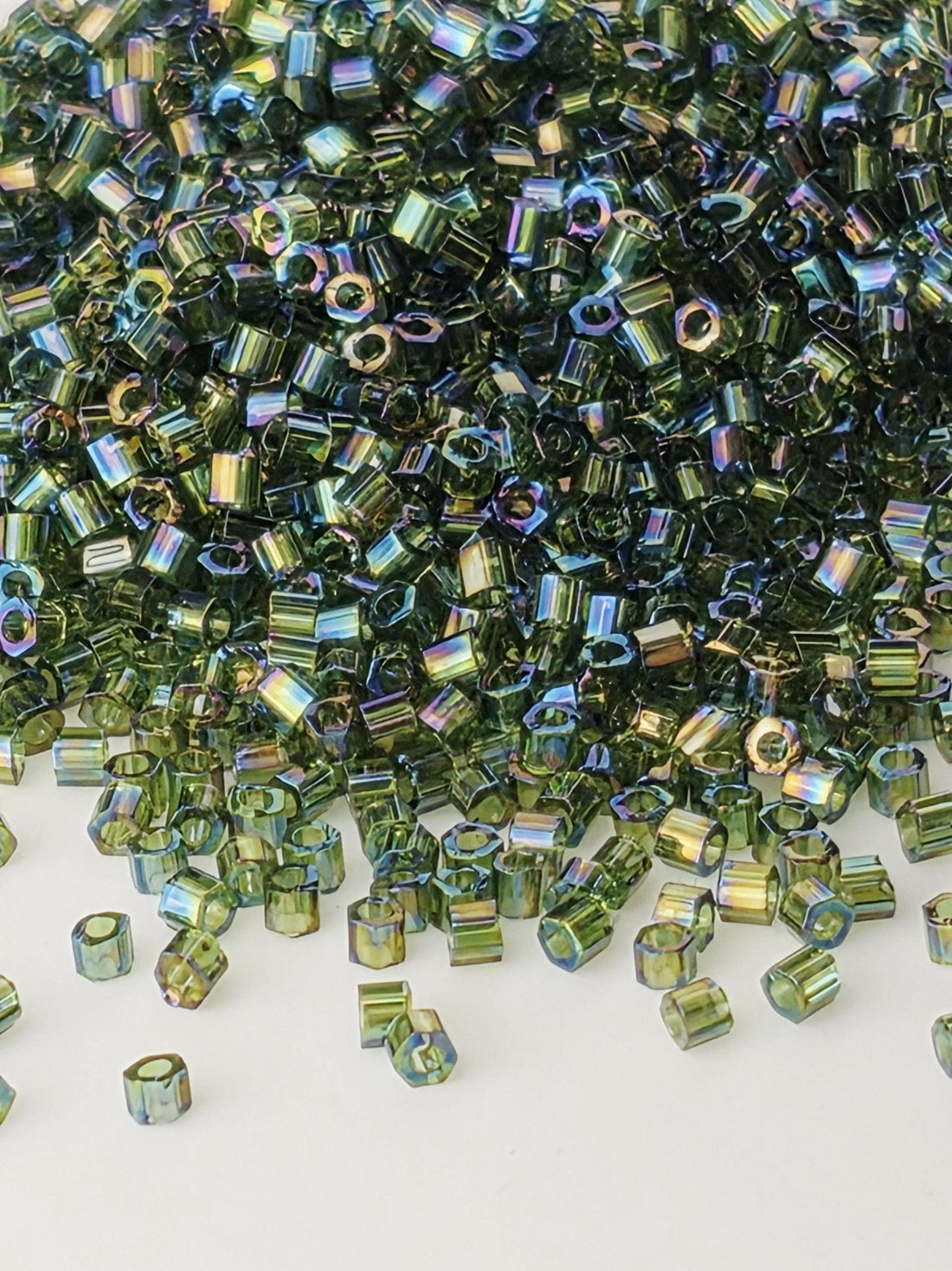 The image is a close-up of a pile of multicolored glass beads or glass pieces, scattered and overlapping each other.