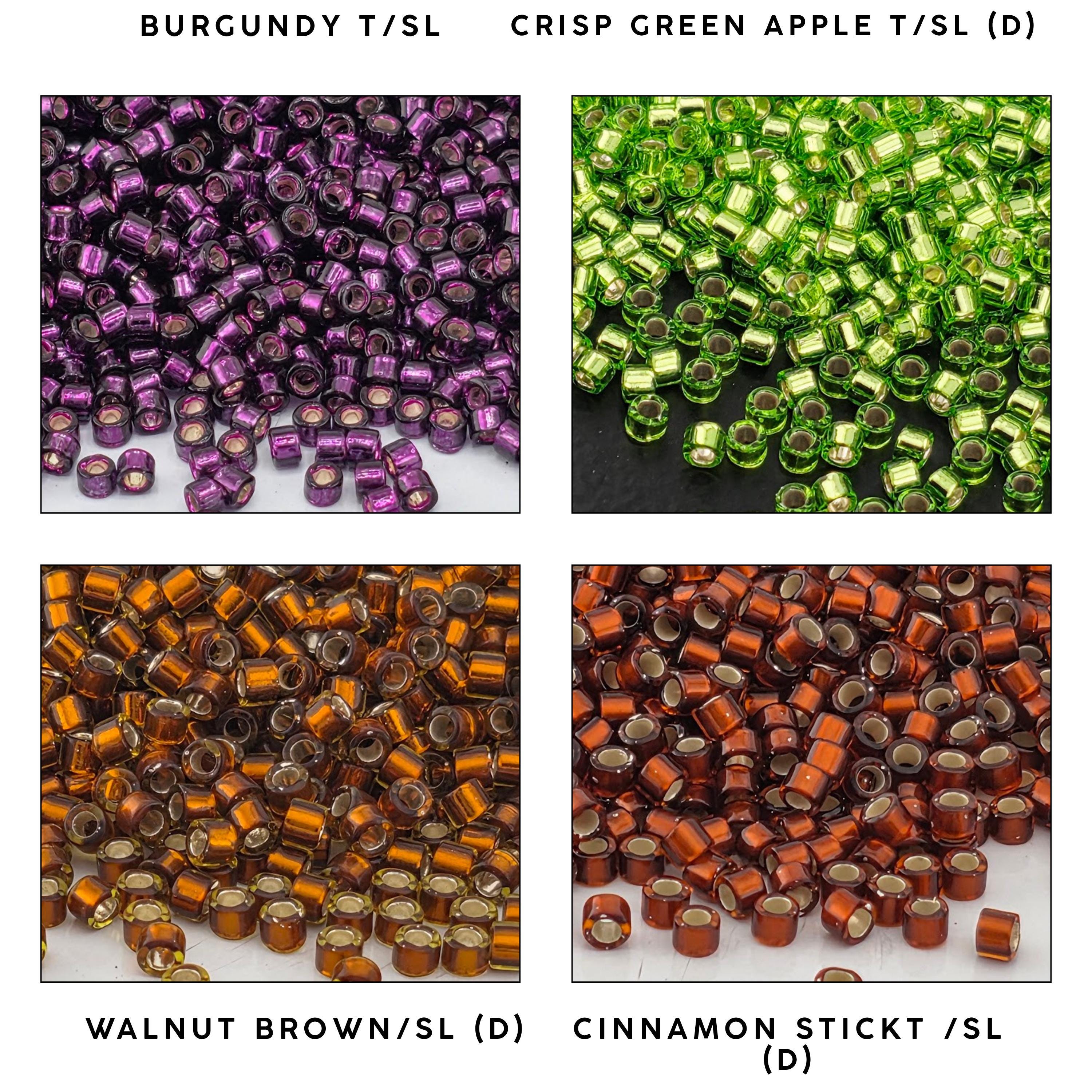four different color piles of beads, each with a unique color and pattern. The piles are labeled as follows: Burgundy (T/SL), Crisp Green Apple (T/SL), Walnut Brown (D), and Cinnamon Stick (SL).