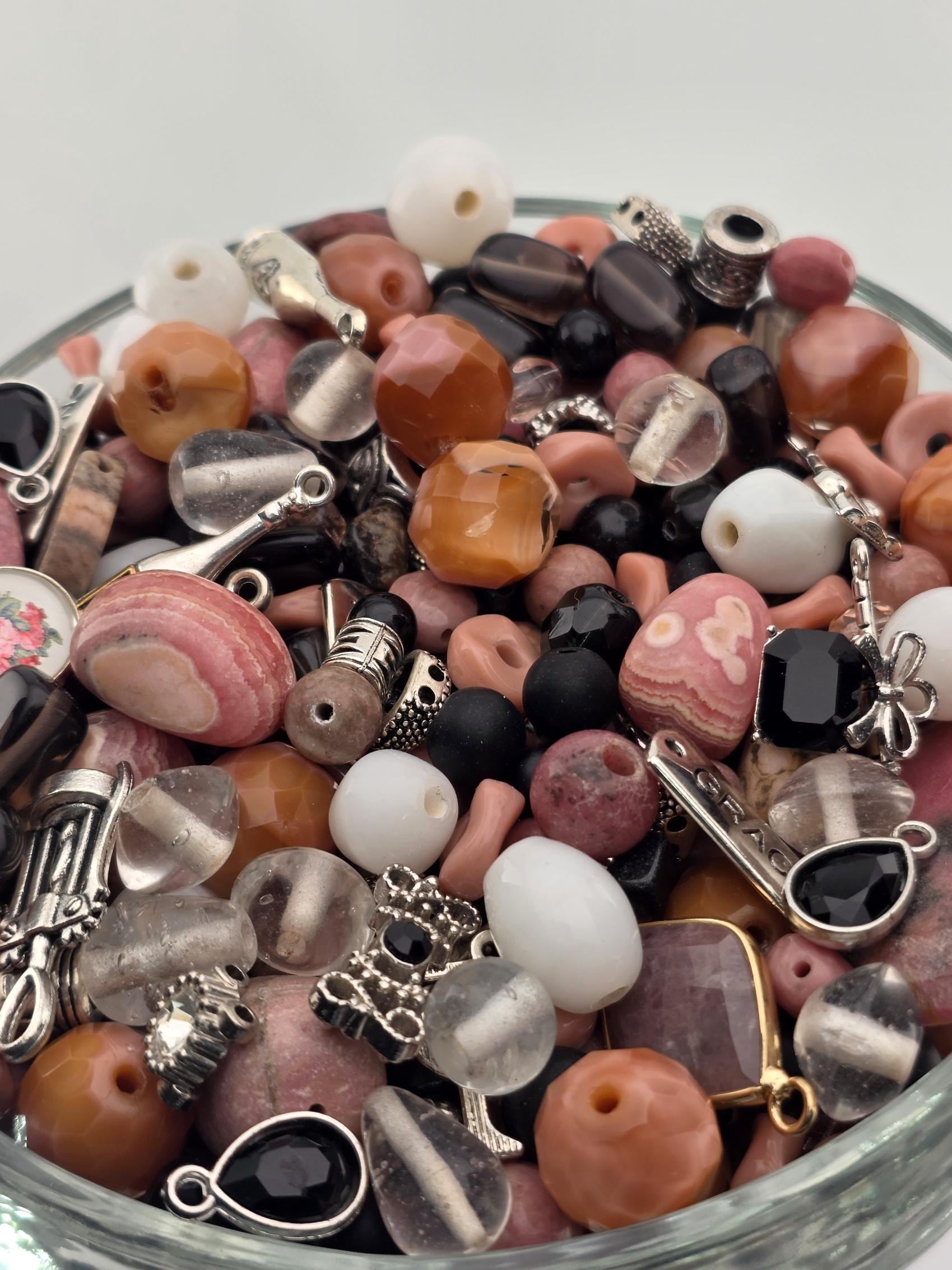 A glass bowl filled with various beads, charms, and other small decorative items.