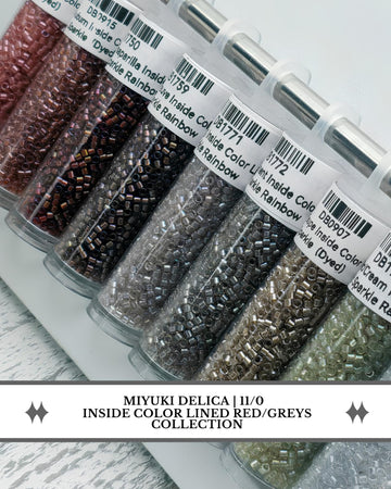a collection of colored beads, including red, grey, and green beads, arranged in rows.