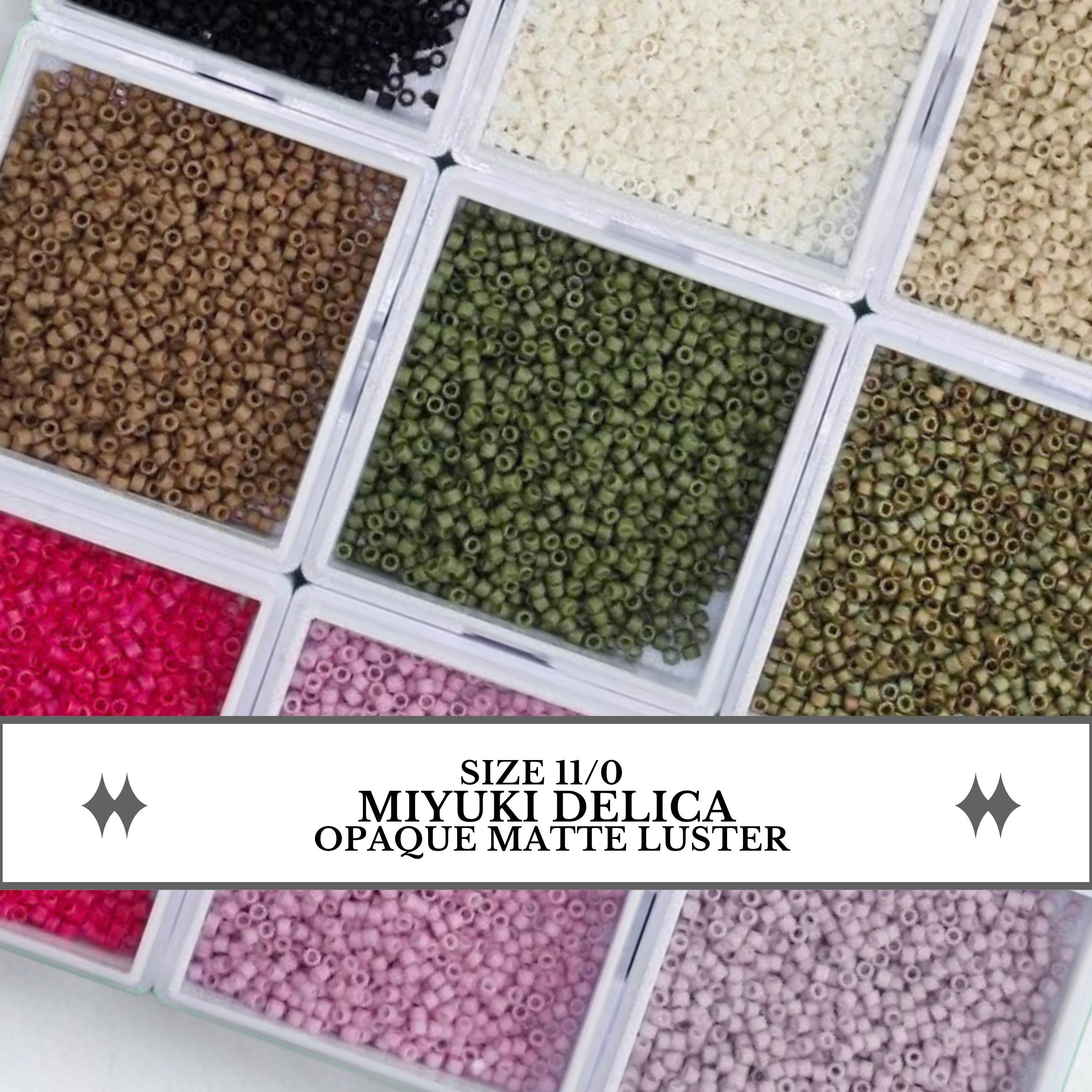 a collection of various colored beads, including black, green, pink, and white, arranged in multiple containers.