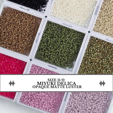 a collection of various colored beads, including black, green, pink, and white, arranged in multiple containers.