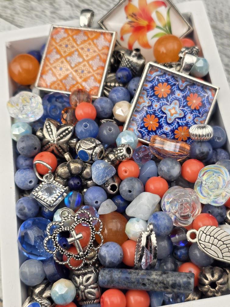 a variety of colorful beads, charms, and pendants arranged in a box or container.