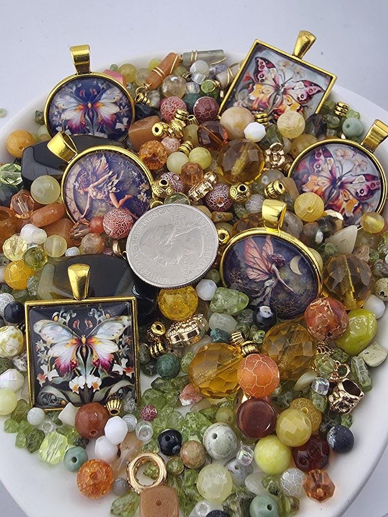 The image is a collection of various colorful beads, charms, and pendants, including butterfly-themed designs, arranged on a white surface.
