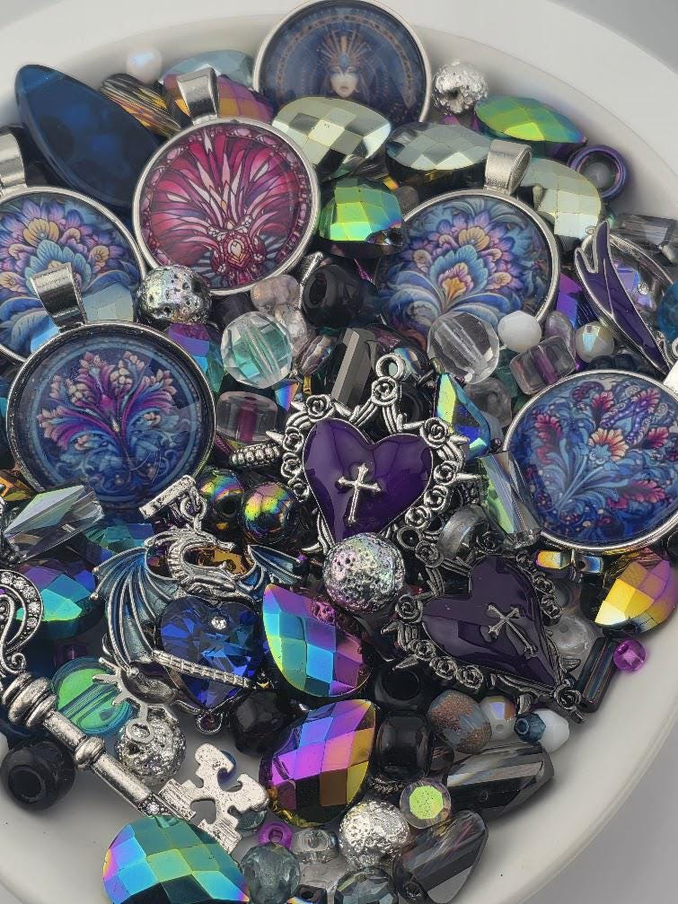 The image is a collection of various colorful beads, charms, and trinkets arranged in a bowl or container.