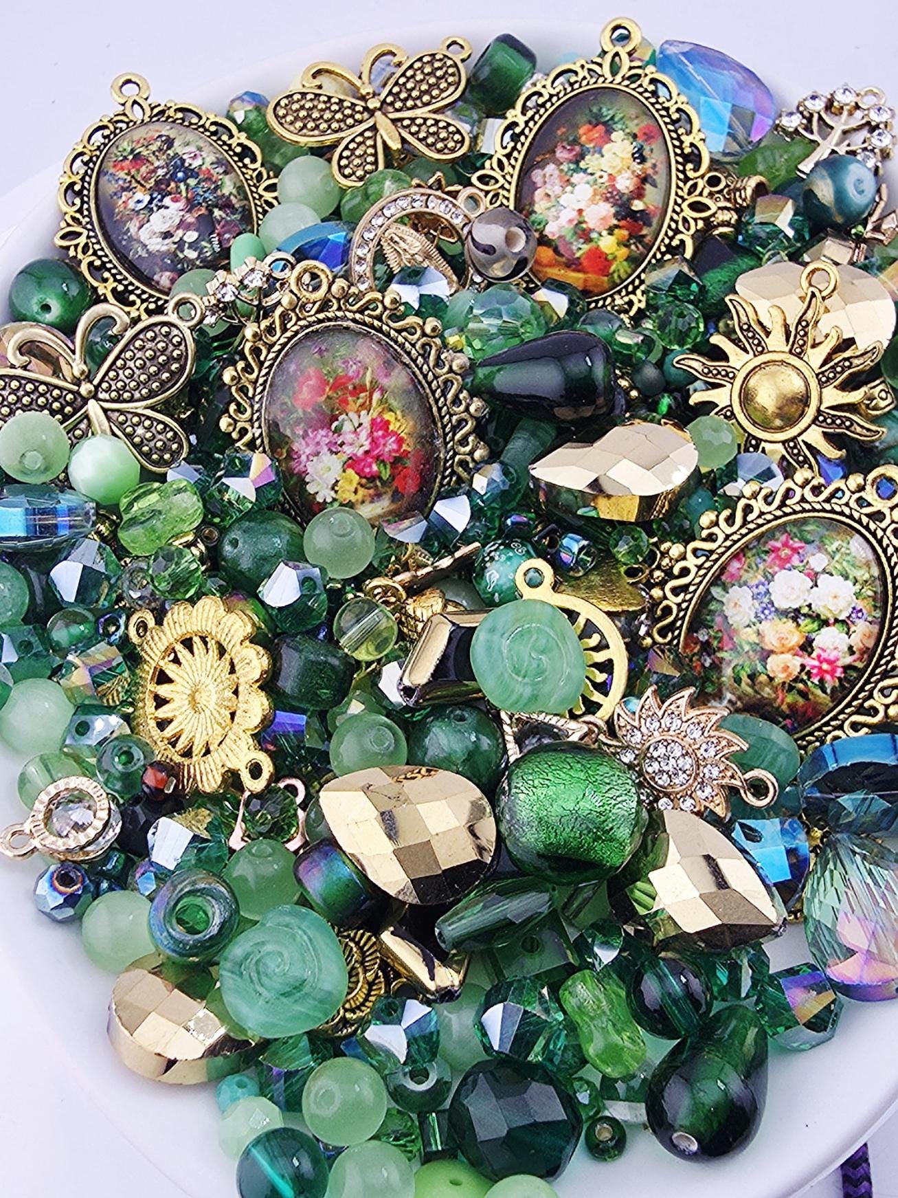 The image is a collection of various colorful beads, charms, and trinkets, including glass beads, metal charms, and other decorative elements, all arranged on a surface.