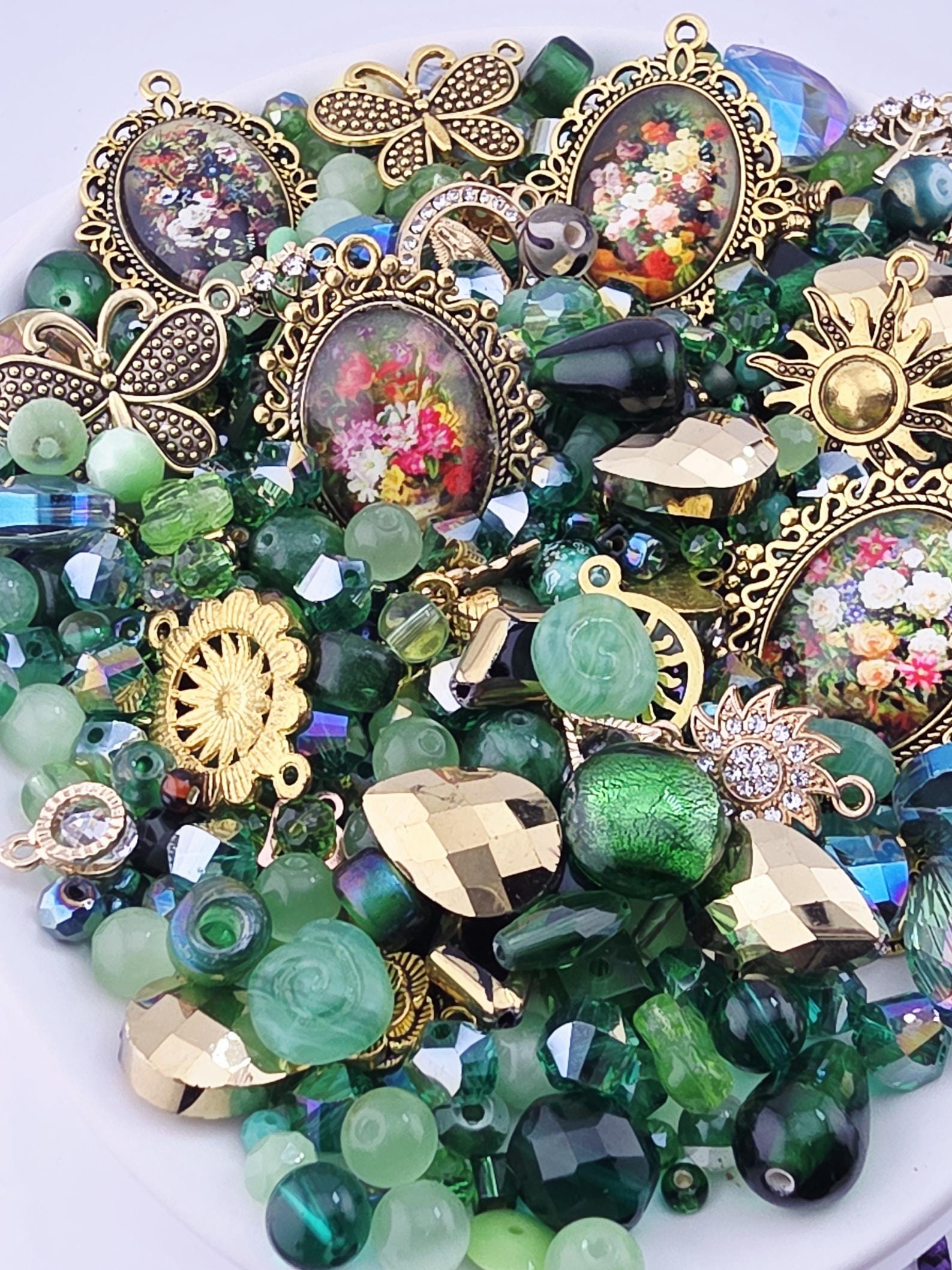 The image is a collection of various colorful beads, charms, and trinkets, including glass beads, metal charms, and other decorative elements, all arranged on a white surface.
