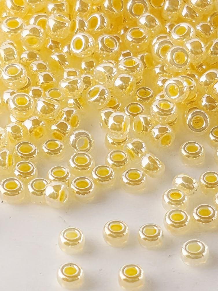 a collection of small, round, yellow beads scattered across a white surface.