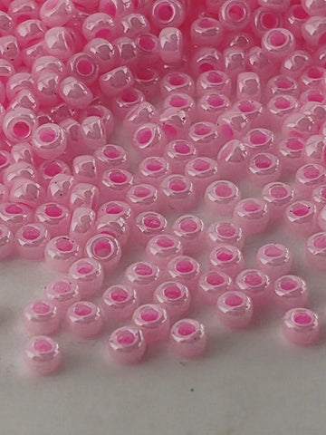 a close-up view of numerous small, round, and shiny pink beads scattered across a surface.