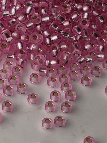 a collection of pink glass beads scattered across a surface, with some of the beads overlapping each other.