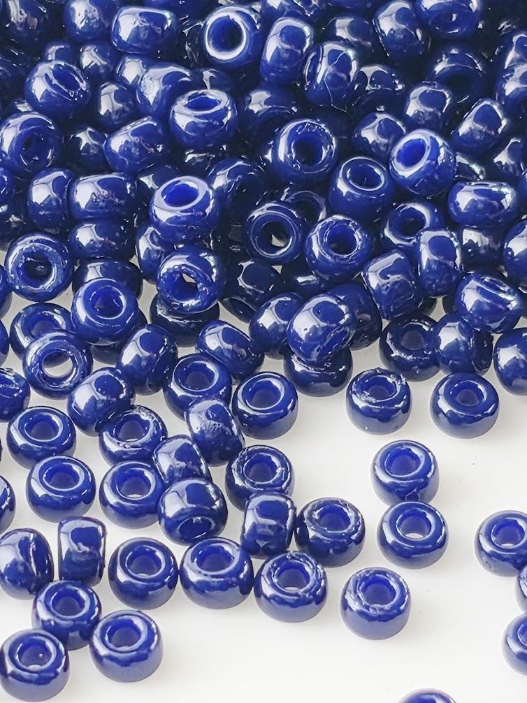 a large pile of blue beads scattered across a white background.