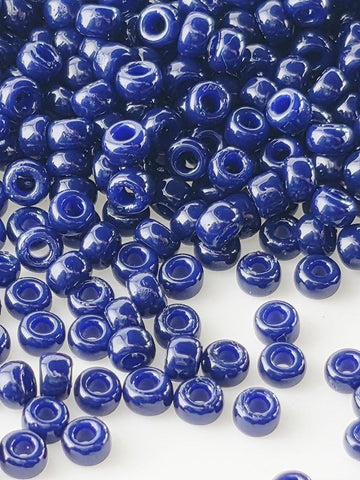 a large pile of blue beads scattered across a white background.