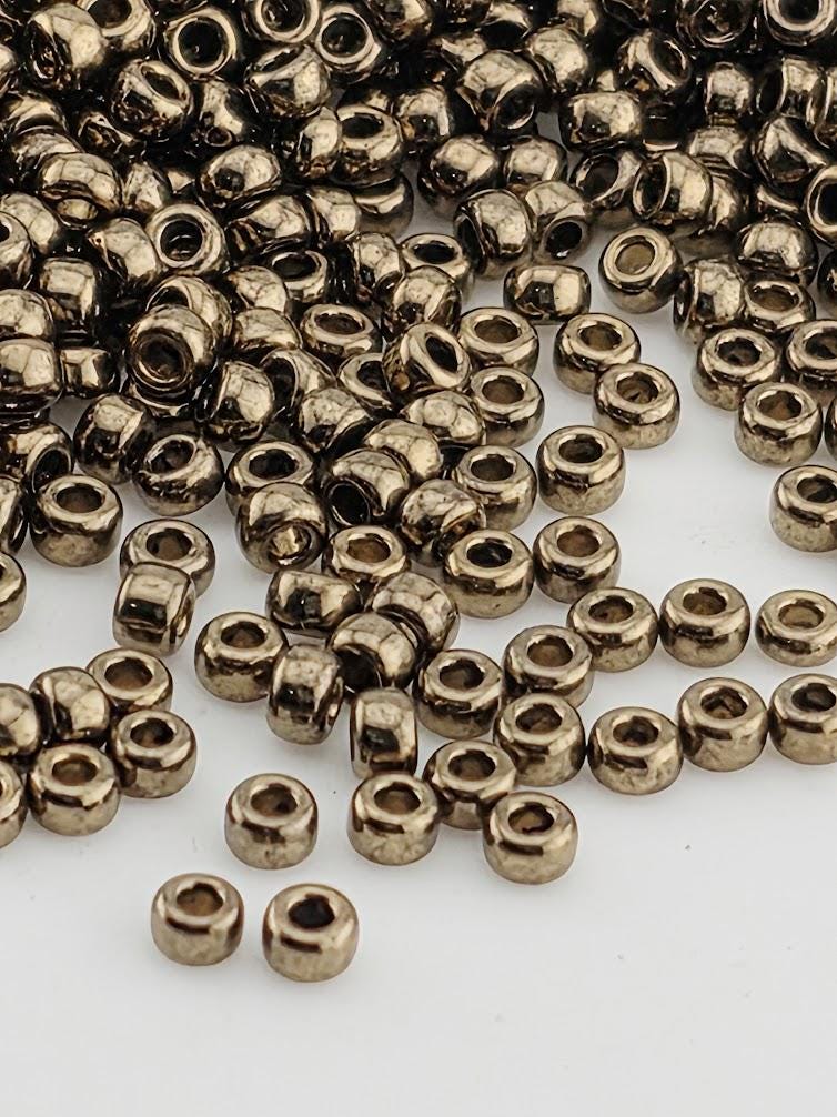 a large pile of small, shiny metal beads scattered across a white background.