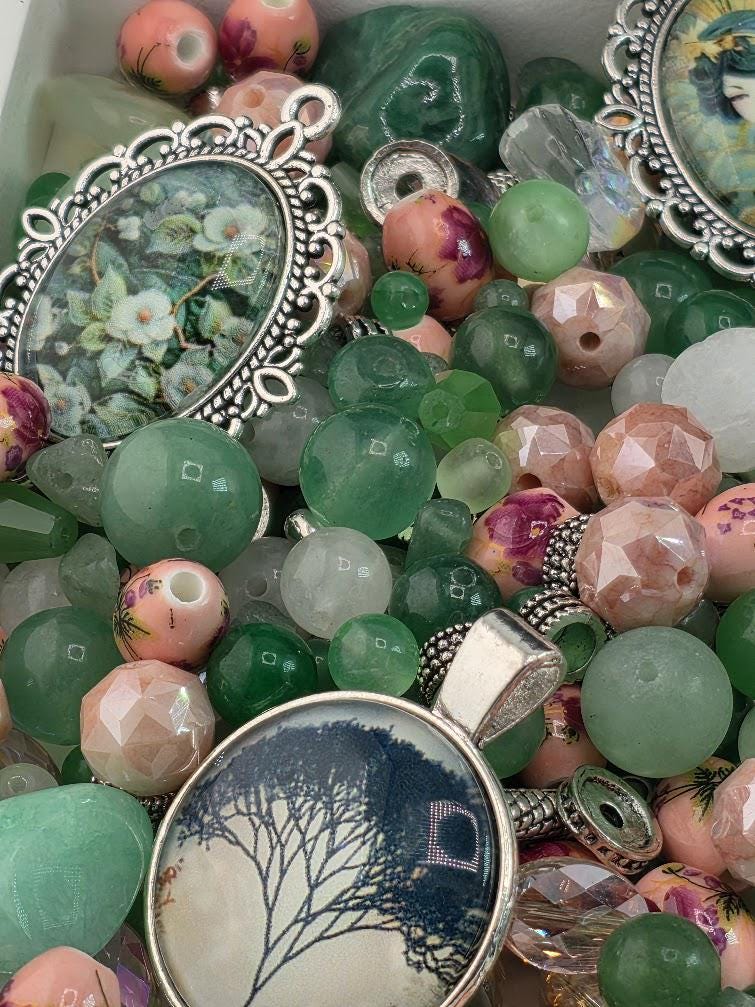 The image is a collection of various beads, charms, and pendants, including glass beads, gemstones, and metal pieces, arranged in a visually appealing manner.