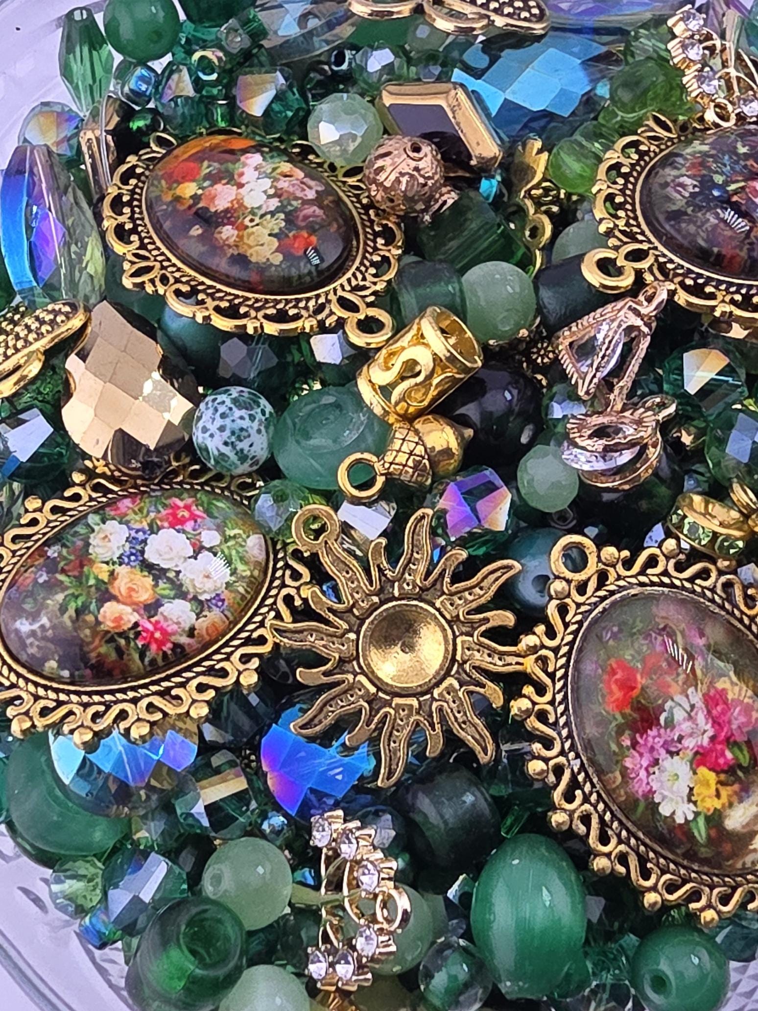 The image is a close-up of a collection of ornate, colorful, and intricate jewelry pieces, including pendants, charms, and beads, all arranged in a visually appealing manner.