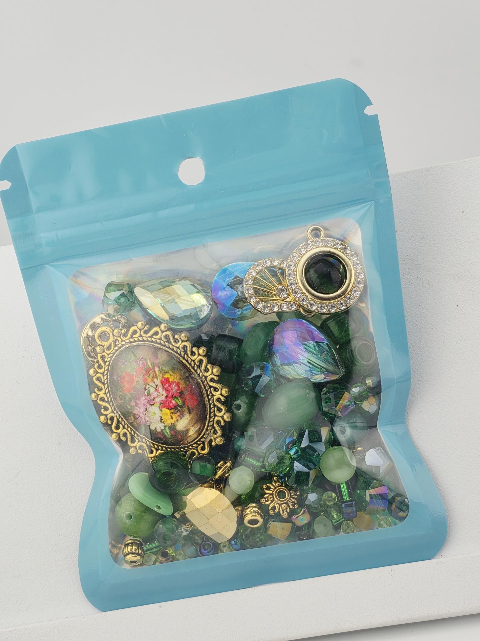 A clear plastic bag filled with various colorful beads, charms, and trinkets.