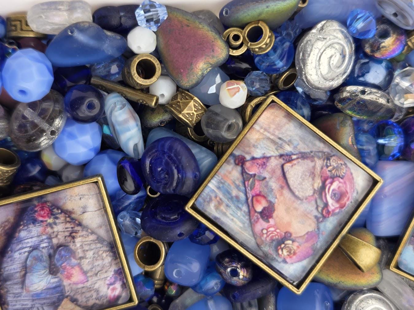 a variety of colorful beads, charms, and other decorative items, including blue, gold, and silver pieces, arranged in a visually appealing manner.
