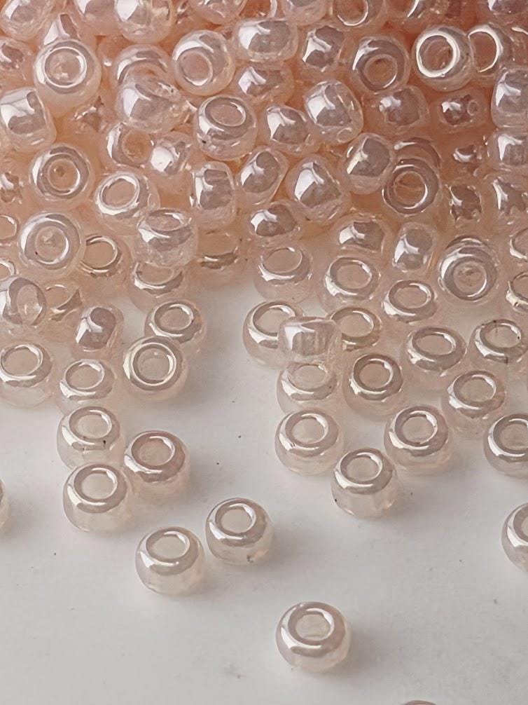 a pile of clear, small beads scattered on a white surface.