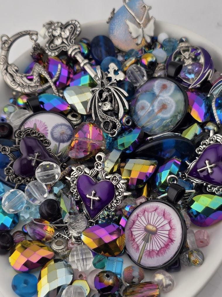 The image is a collection of various colorful beads, charms, and trinkets arranged on a surface.