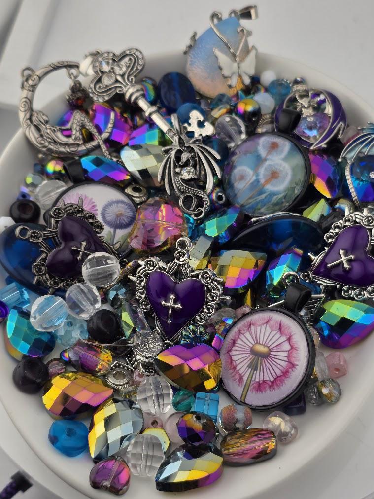The image is a collection of various colorful beads, charms, and trinkets arranged in a bowl or container.