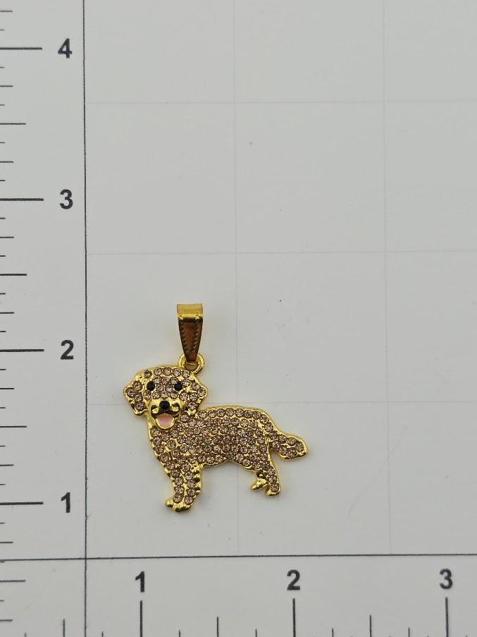 A gold-colored pendant in the shape of a dog is shown on a white background, with a ruler for scale.