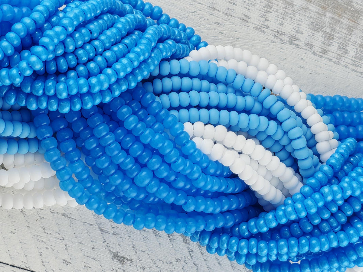 A close-up view of a collection of blue and white beads arranged in a circular pattern on a wooden surface.