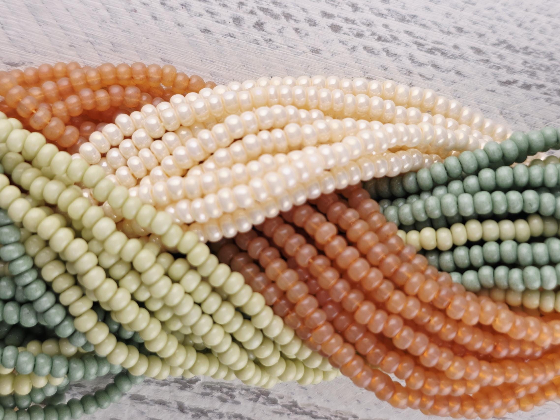 A close-up image of a collection of colorful beads, including orange, green, and white beads, arranged in a visually appealing manner.