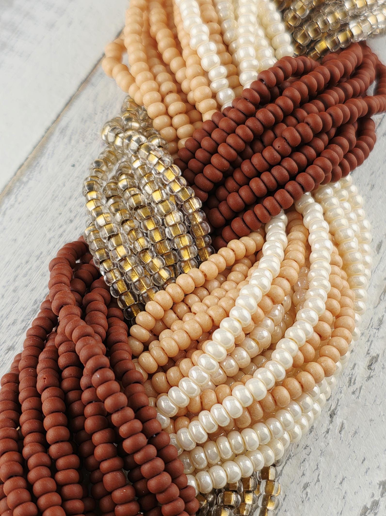 A collection of various colored beads, including brown, white, and beige beads, arranged in a visually appealing manner.
