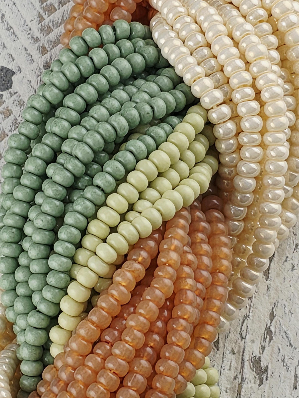 A collection of colorful beads, including white, green, orange, and yellow beads, arranged in a visually appealing manner.