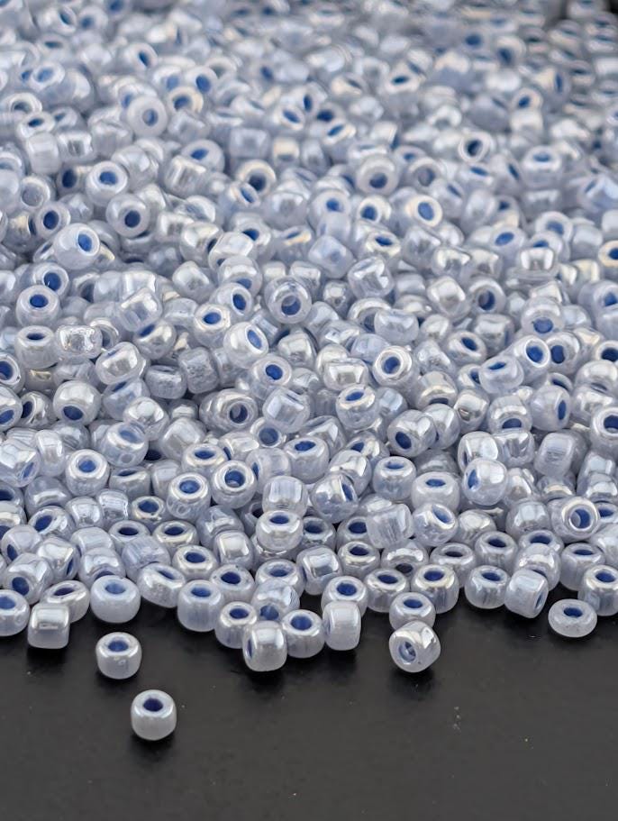 a large pile of small, clear beads scattered on a dark surface.
