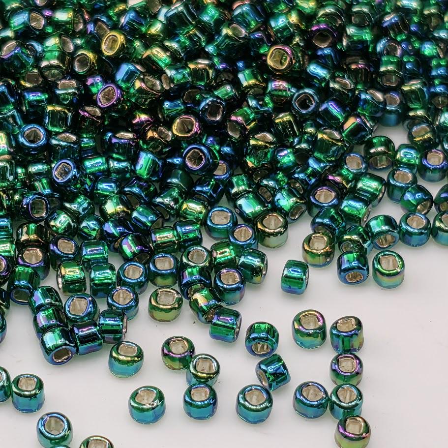 a large pile of multicolored glass beads scattered across a white surface.