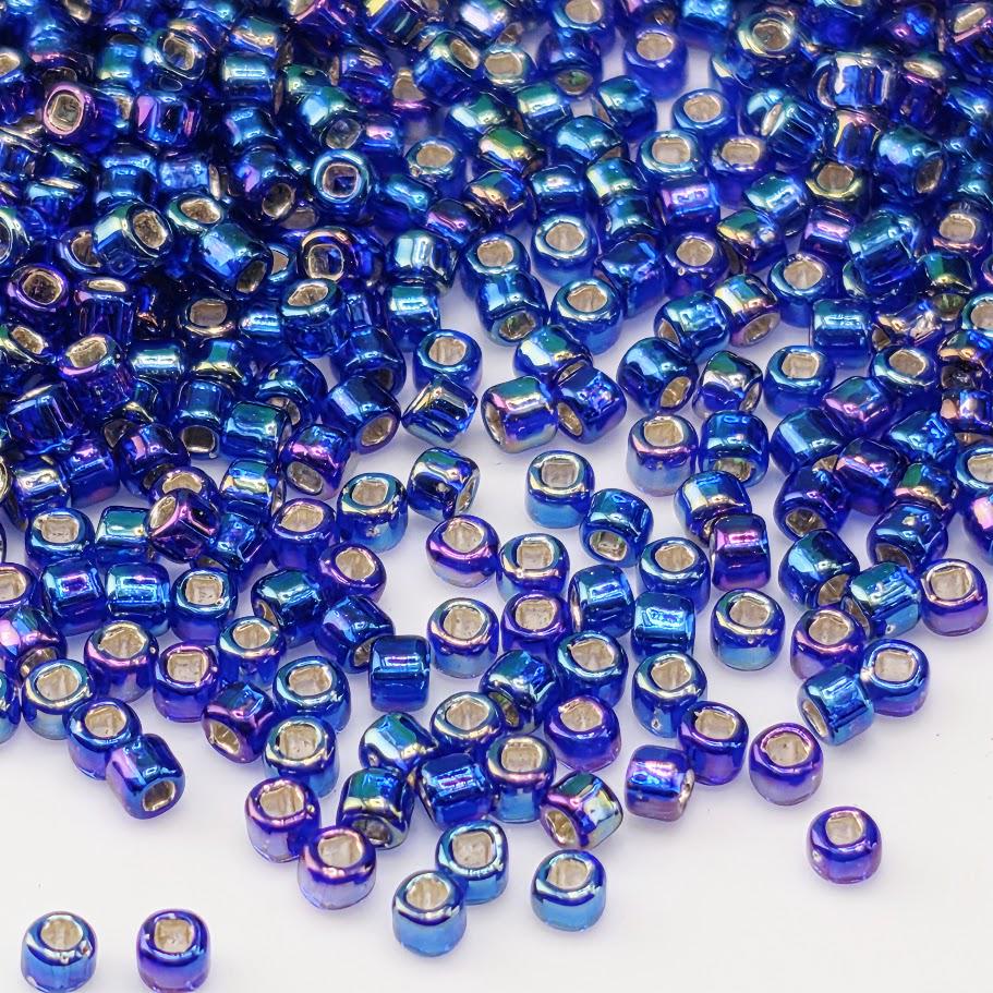 a large number of small, shiny blue beads scattered across a white background.
