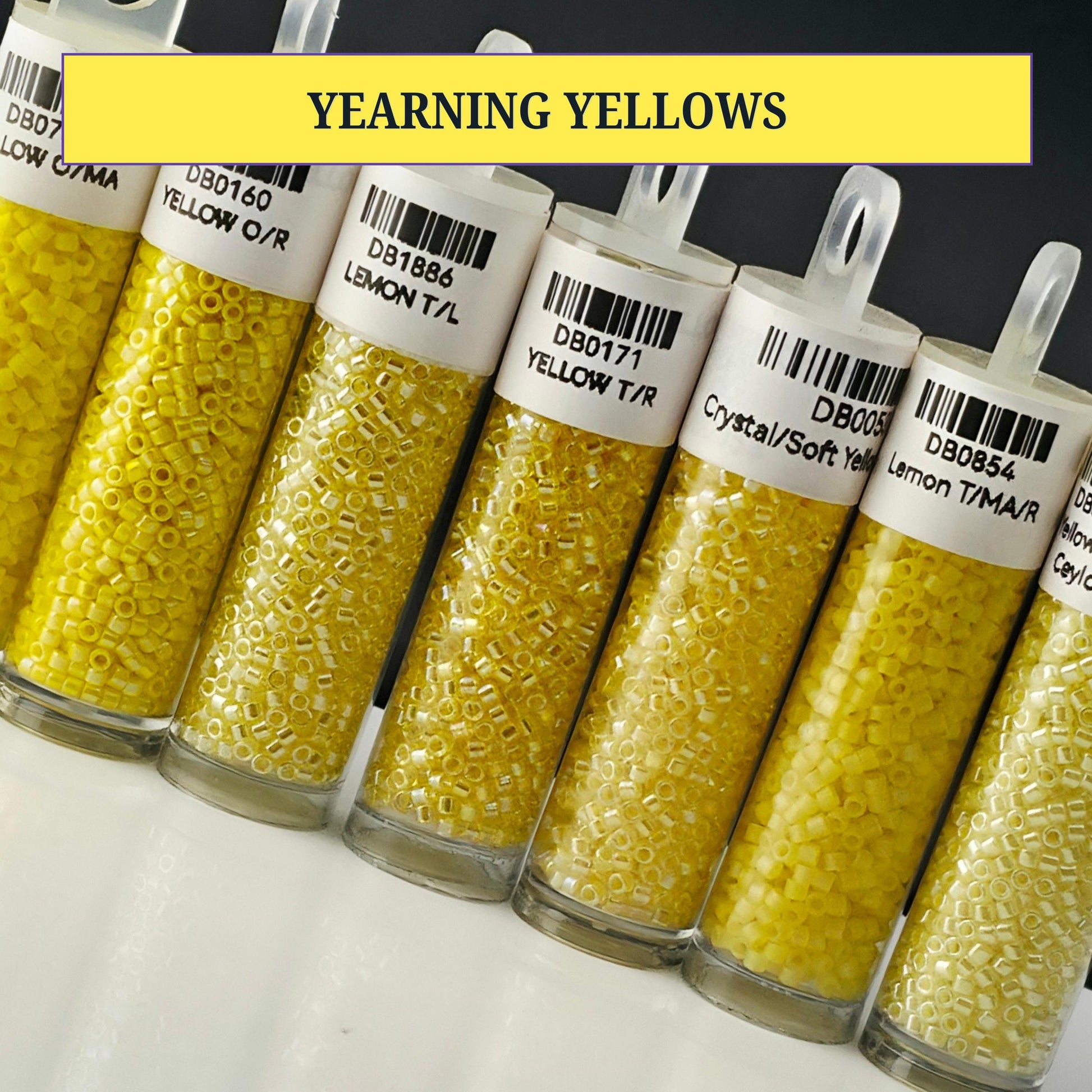 A collection of glass containers filled with yellow beads, each labeled with a different color.